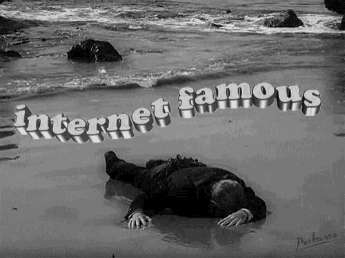 a black and white photo of a man laying on the beach with the words internet famous written above him
