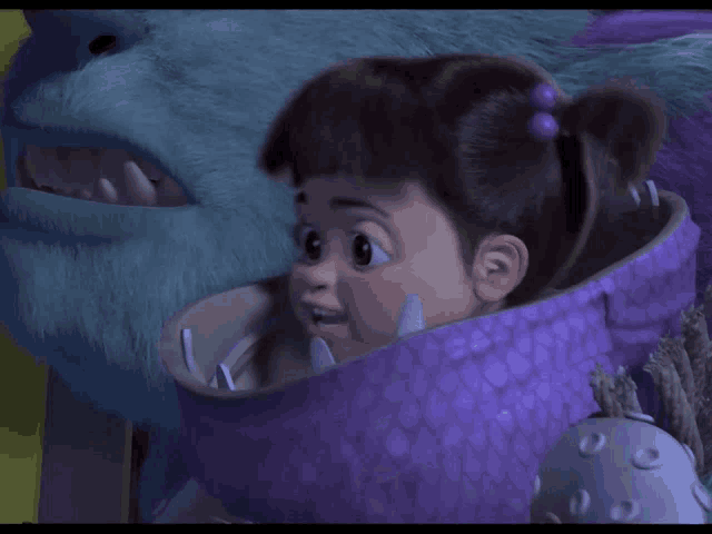 a little girl in a purple monster costume looks at a blue monster