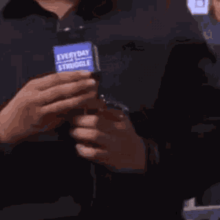 a person is holding a microphone that says `` everyday struggle '' on it .