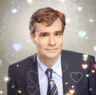 a man in a suit and tie with hearts on his suit
