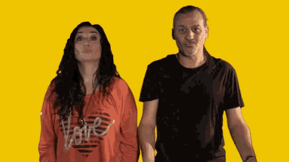 a man and a woman are standing next to each other with the woman wearing a red shirt that says love