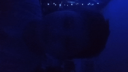 a dark room with a blue light shining through the ceiling