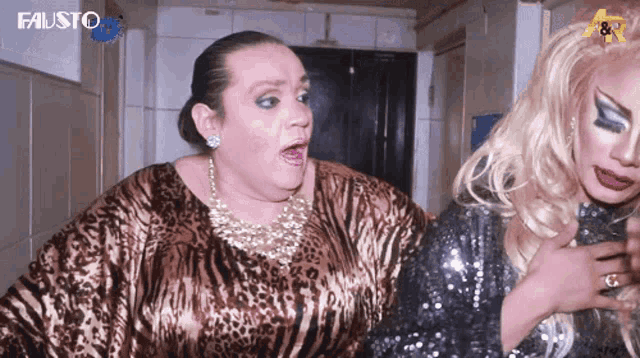 a woman in a leopard print dress stands next to a blonde woman in a sequined dress