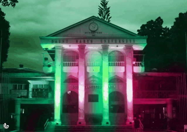 a building that says saint mary 's university is lit up with green and red lights
