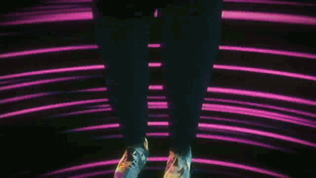 a person is standing in a dark room with purple and blue lights