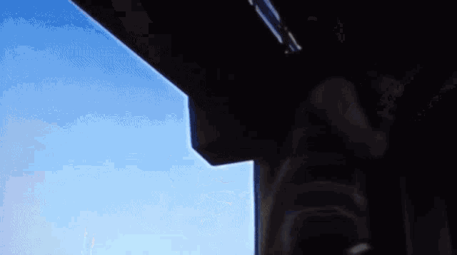 a silhouette of a person is against a blue sky .