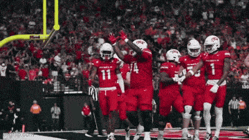 a group of football players in red uniforms with the number 11 on the back
