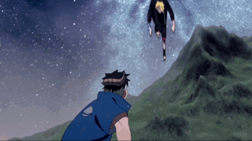 a man in a blue vest is standing on a hill looking at a man in a black shirt flying in the sky