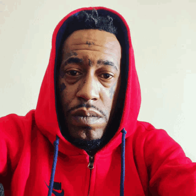 a man is wearing a red nike hoodie