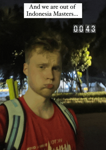 a man wearing a red shirt and a backpack is standing in front of a sign that says and we are out of indonesia masters ...