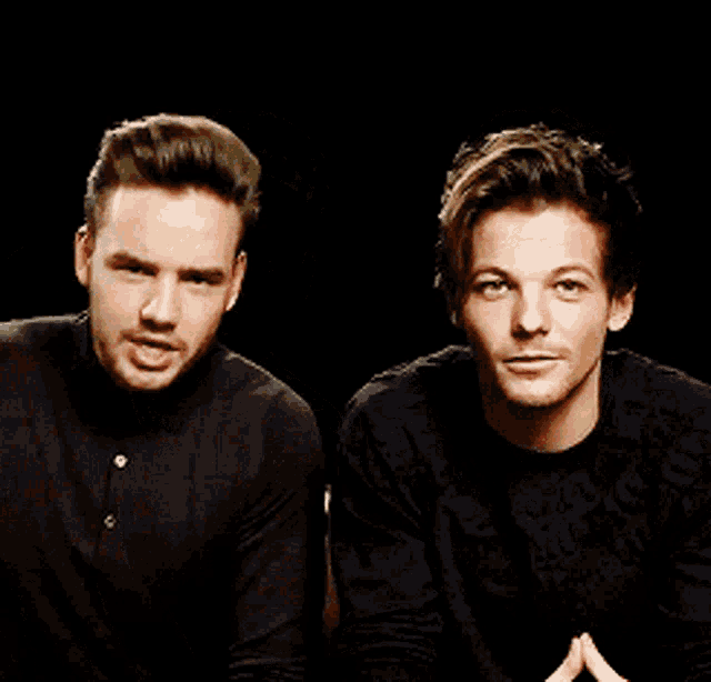 two men are standing next to each other and one is pointing up