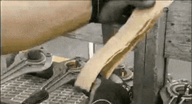 a person is cutting a piece of wood on a table with a saw .