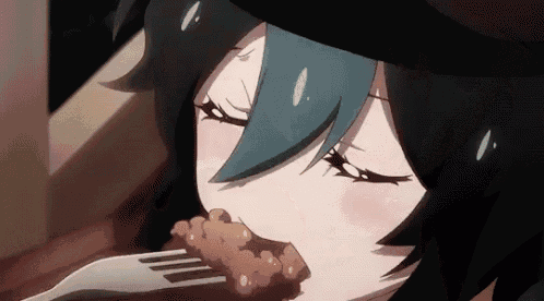 a close up of a girl eating a piece of meat with a fork .
