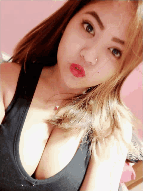 a woman wearing a black tank top has a nose ring on her nose