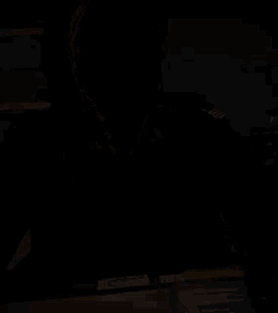 a woman in a military uniform is sitting at a desk looking at something
