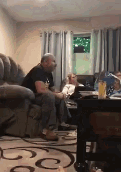 a man sitting on a couch in a living room with a woman sitting on a couch