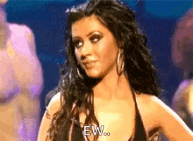 a woman in a black bikini top is making a funny face while standing on a stage .