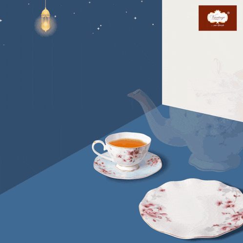 a cup of tea sits on a saucer next to a plate and a teapot