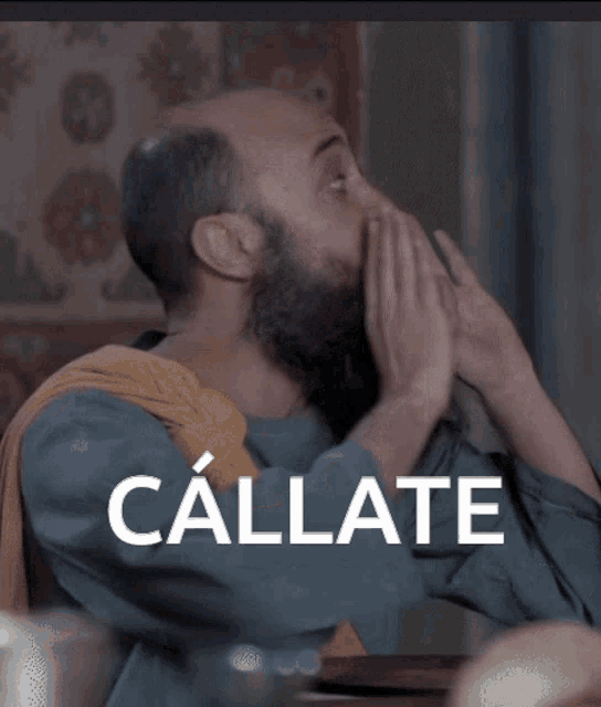 a man with a beard has the word callate written on his face