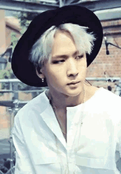 a man wearing a white shirt and a black hat