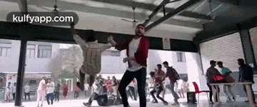 a group of people are dancing in a room in front of a crowd of people .