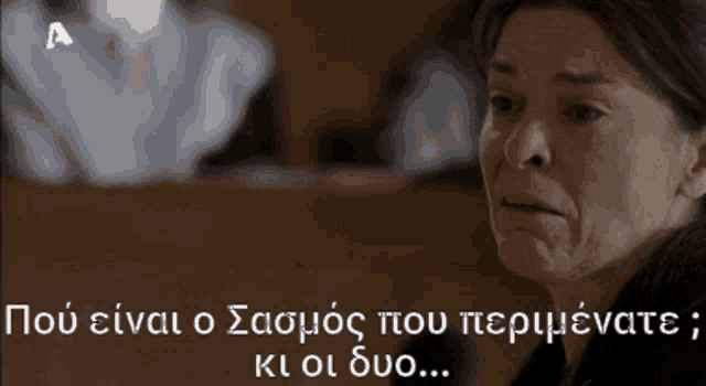 a woman is crying in front of a sign that says " a "