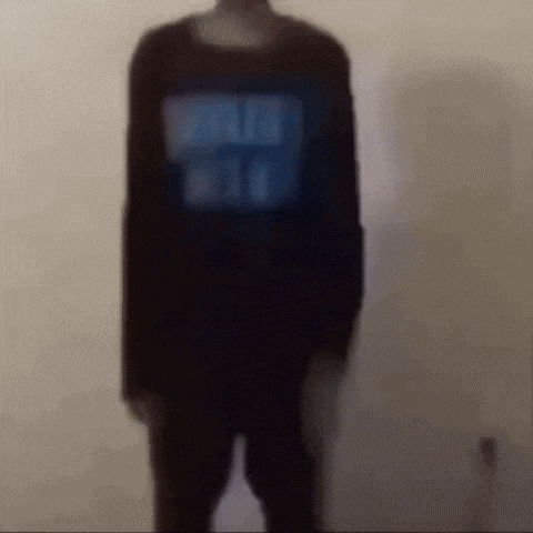 a blurry picture of a person standing in front of a wall .