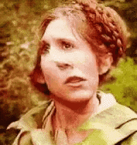 a close up of a woman 's face with trees in the background .