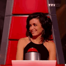a woman is sitting in a chair with a tfhd logo on the bottom