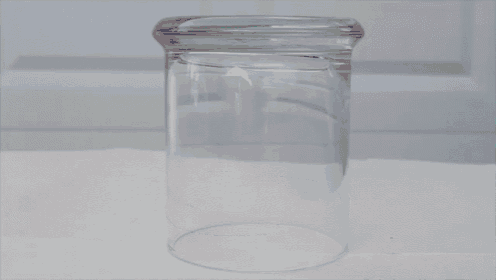 a clear glass jar with a swirl of colored bands on it