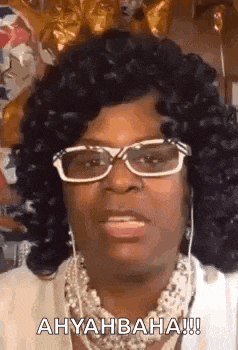 a woman wearing glasses and a necklace is making a face .