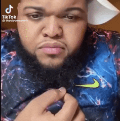 a man with a beard and a hat is wearing a nike shirt .