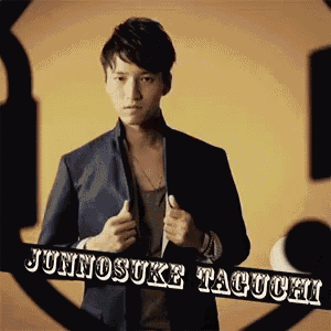 a man in a suit is holding a banner that says junnosuke taguchi