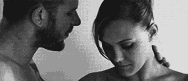 a man and a woman are looking at each other in a black and white photo .