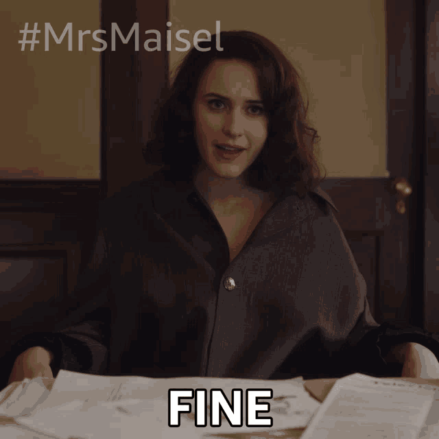 a woman sitting at a desk with papers and the word fine written on it
