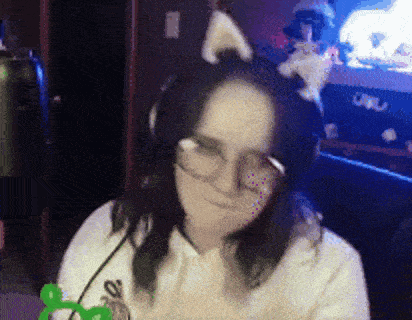 a woman wearing headphones and cat ears is making a face .