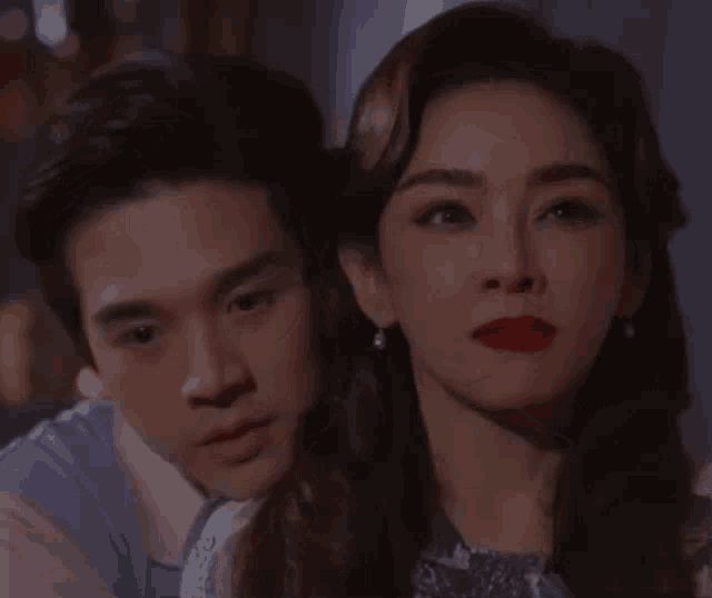 a man and a woman with red lipstick are looking at something
