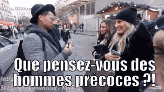 a man in a hat is talking to a woman on a street and the caption reads que pensez-vous des hommes precoces