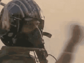 a close up of a fighter jet pilot wearing a helmet .