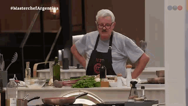 a man wearing an apron that says masterchef argentina on it