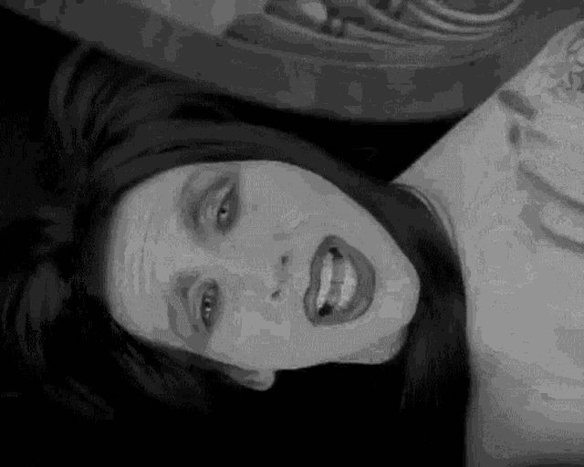 a black and white photo of a woman laying on her back .