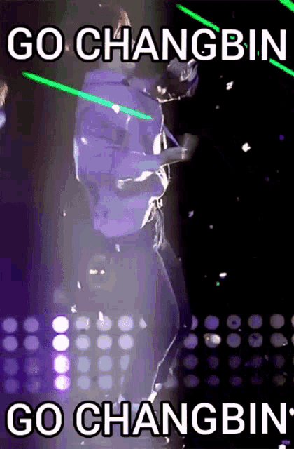 a picture of a person holding a green light saber with the caption go changbin go changbin