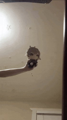 a person holding a stuffed animal in front of a ceiling