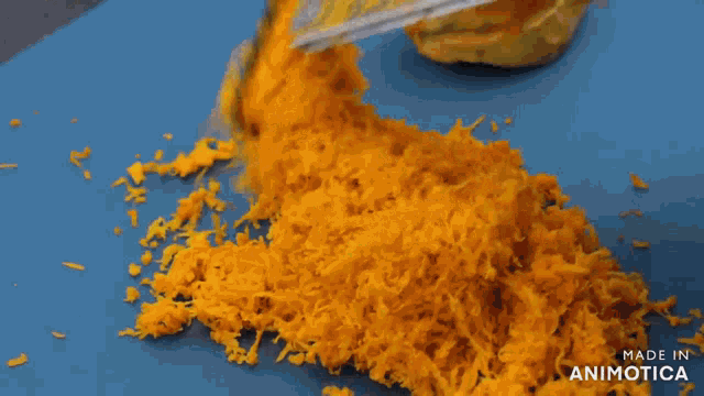 a person wearing white gloves is grating something on a blue cutting board made in animatica