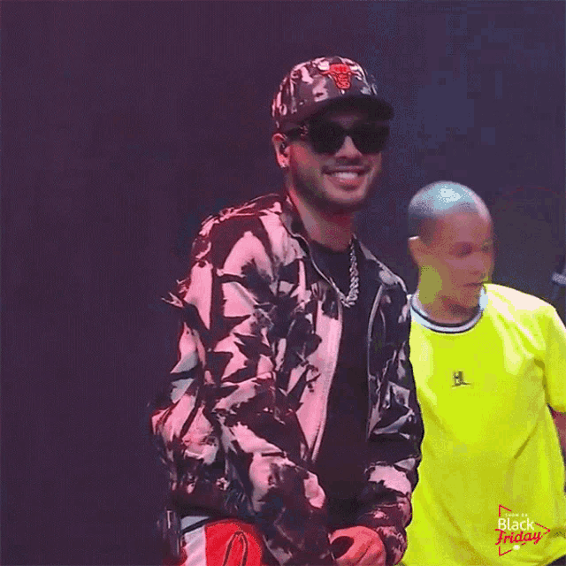 a man wearing a chicago bulls hat and sunglasses is smiling
