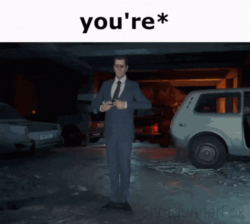 a man in a suit and tie is standing in a garage with the words you 're *