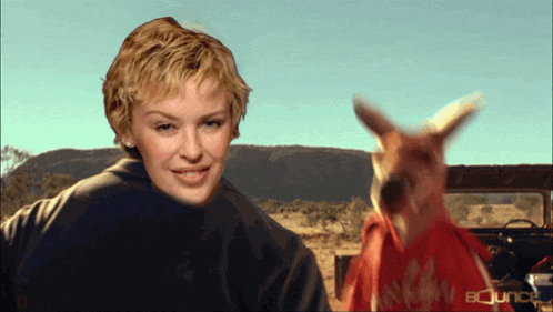a woman standing next to a kangaroo with the words bounce on the bottom right