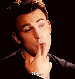 a man in a suit and tie is covering his mouth with his hand .