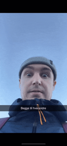 a man wearing a beanie and a jacket with the words begge til hverandre written on it