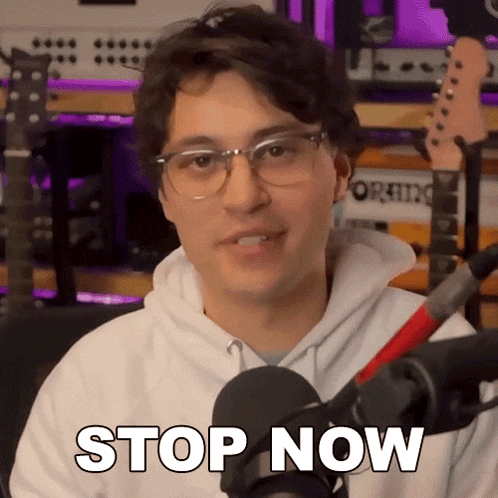 a young man wearing glasses and a white hoodie says stop now